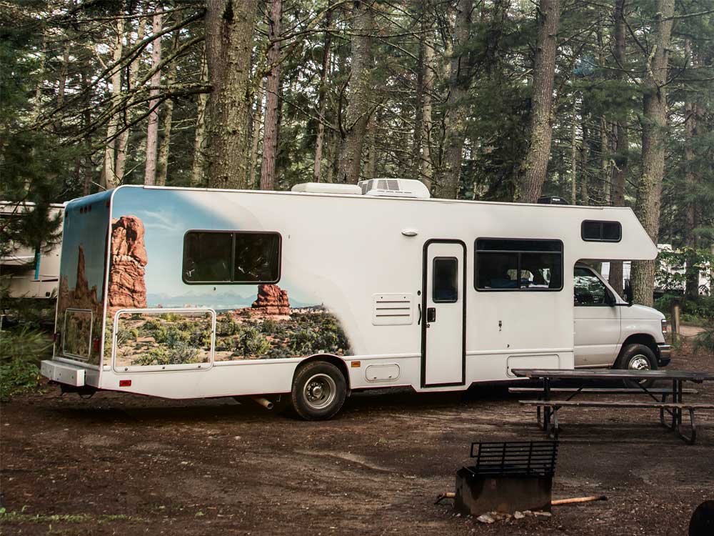 large-class-c A large Class C RV parked in a forested campsite