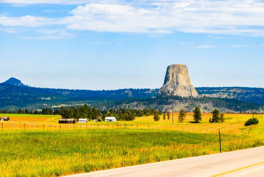 Devils Tower Wyoming with yellow fields in front Devils Tower Wyoming with yellow fields in front from Tumbleweed Travel