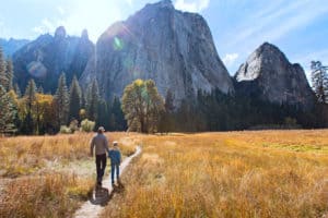 back view of active family of two father and son enjoying valley and mountain view in yosemite national park california active family vacation concept from Tumbleweed Travel
