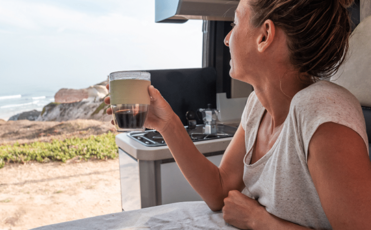 How to Make Coffee While Traveling in an RV Woman enjoying coffee in an RV from Tumbleweed Travel